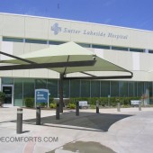 Shade structure cools car drop off and pick up zone at hospital.