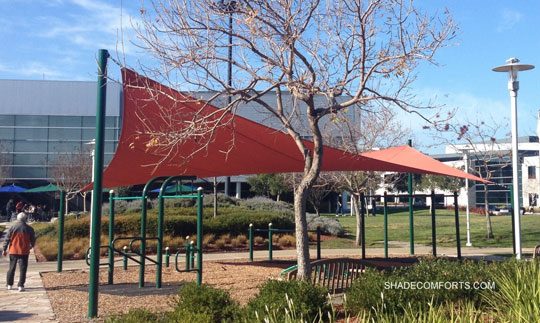 See photo of a tensile shade structure at a Santa Clara County manufacturing company. The hypar shade sail covers an outdoor fitness center used by employees.