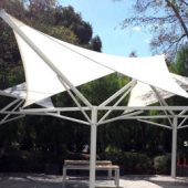 See photo of permanent hypar shade umbrellas on the courtyard patio between Santa Clara County office buildings. We designed and constructed these tensile structures.