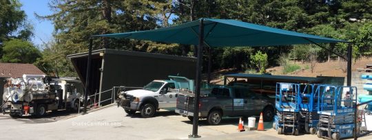 This fabric shade canopy protects maintenance vehicles from UV damage at this municipal corporate yard. The sun used to break down the rubber hoses and gaskets, which rendered the trucks undependable when needed for emergencies.