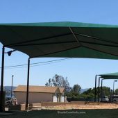 This volleyball court shade structure (shown in foreground) is in Lake County, CA. It measures 80’x50’ with a 20’ clearance height. One 4,000 square foot fabric is tensioned on hip framing atop (6) posts.