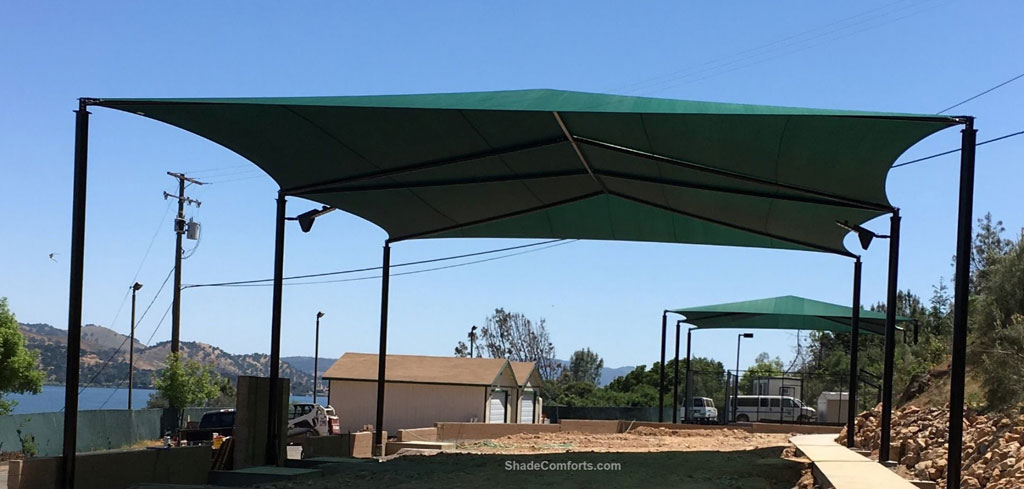 This volleyball court shade structure (shown in foreground) is in Lake County, CA.  It measures 80’x50’ with a 20’ clearance height.  One 4,000 square foot fabric is tensioned on hip framing atop (6) posts.