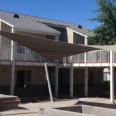 See photo of a tensile shade structure on the courtyard patio at a Contra Costa apartment complex. Shade Comforts designed, fabricated, and constructed this hypar shade structure.