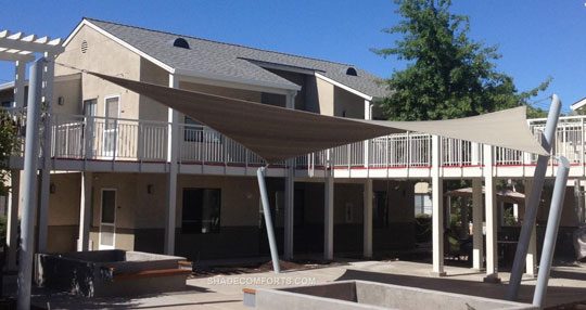 See photo of a tensile shade structure on the courtyard patio at a Contra Costa apartment complex. Shade Comforts designed, fabricated, and constructed this hypar shade structure.