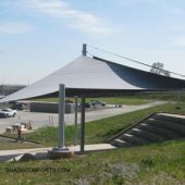 See photo of a tensile shade structure covering bleachers at a Sacramento company. Four hypar sail fabrics create permanent outdoor sun protection.