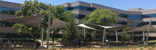 This tensile structure shades the employee patio in the central courtyard of a large commercial office park east of Oakland, CA. It has four hypar shade sails.
