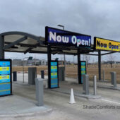 This tensioned fabric shade structure near Omaha, NE is waterproof and withstands snow load. It covers Pay Stations at a Chevrolet dealership.