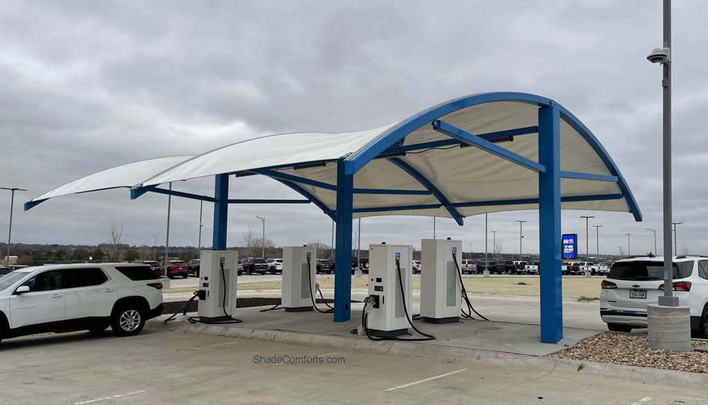 This tensioned fabric shade structure near Omaha, NE is waterproof and withstands snow load. It covers the EV Charging stations at a Chevrolet dealership.