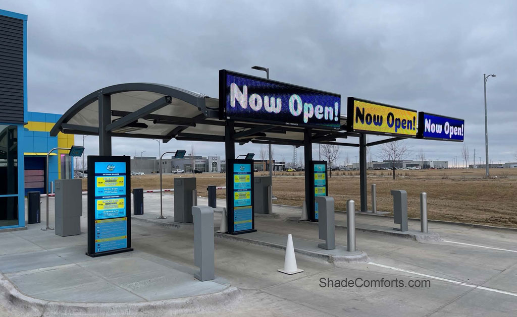 This tensioned fabric shade structure near Omaha, NE is waterproof and withstands snow load. It covers Pay Stations at a Chevrolet dealership.