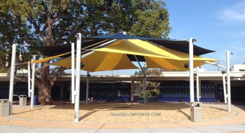 We designed and constructed this custom patio shade sail structure with two layers of tensioned fabric over a commercial courtyard.”