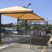 shuttle stop shade structure keeps passengers cool while awaiting minibus pickup. The fabric canopies cover the entire waiting area.