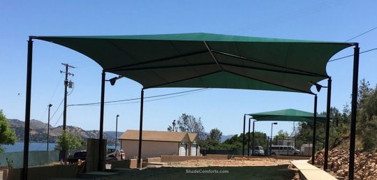 This volleyball court shade structure (shown in foreground) is in Lake County, CA. It measures 80’x50’ with a 20’ clearance height. One 4,000 square foot fabric is tensioned on hip framing atop (6) posts.