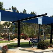 Three shade sail structures cool the front walkway and entrance to Kaiser Permanente in the Riverside County community of Corona, CA. Single plane shade sail extend between cantilevered beams.